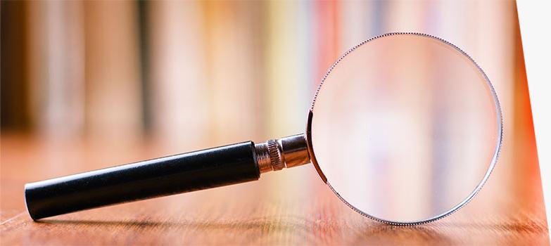 A magnifying glass on a wooden floor.